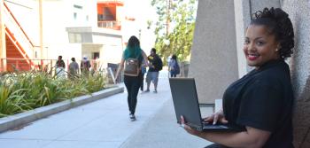 Senior Student with Laptop Outside Building