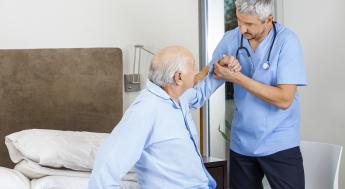 Nursing Assistant helping elderly man