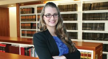 female paralegal standing in law library