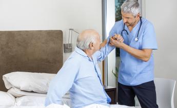 Nursing Assistant helping elderly man