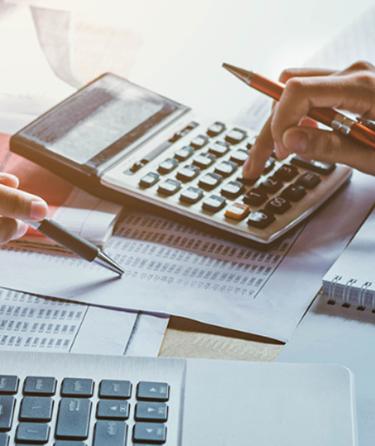 woman's hand on calculator with spread sheet