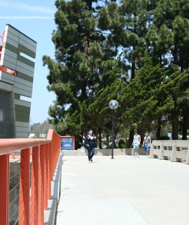 person crossing campus bridge