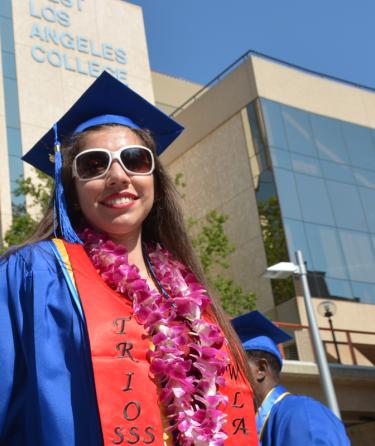 Student wearing TRiO sash with graduation robe