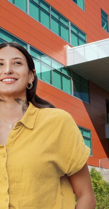 smiling woman walking on college campus with image text reading zero tuition promise program