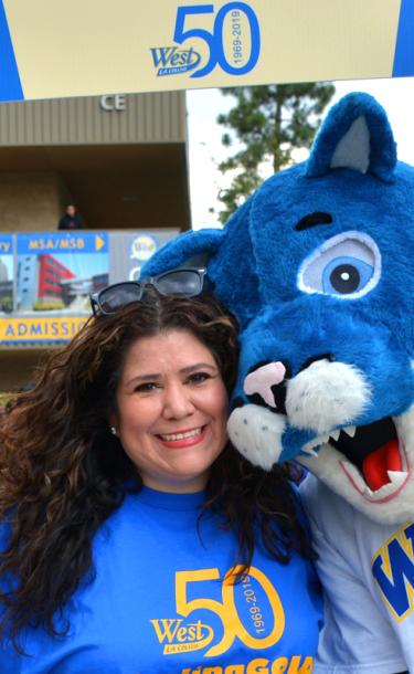 Wildcat mascot and college employee at college carnival