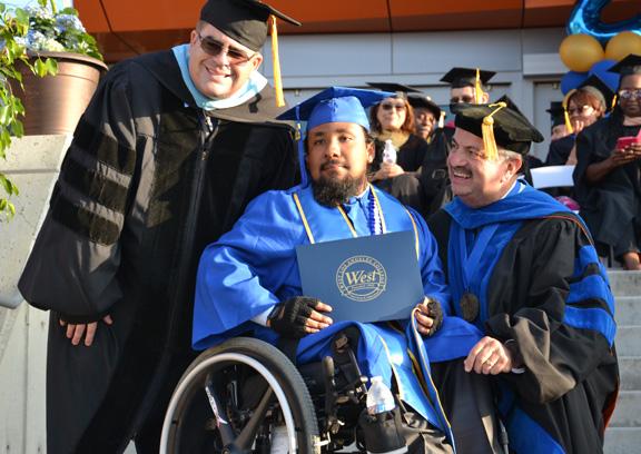 student in wheelchair receiving diploma at graduation