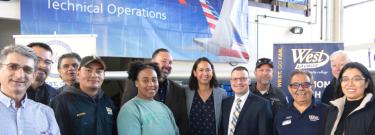 In the center from left, Dr. Jim Lancaster, LACCD Vice Chancellor; Evie Garces, American Airlines Vice President of Line Maintenance; and Jeffrey Archibald, WLAC Vice President are surrounded by aviation students, faculty, staff and alumni